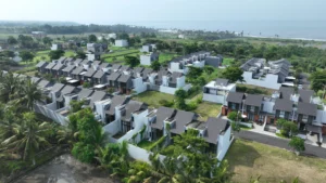 Aerial view of Ciputra Beach Resort in Bali, showcasing modern residential units surrounded by lush greenery and close proximity to the beach.